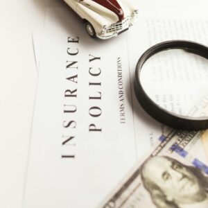 Car insurance paperwork being checked with a magnifying glass